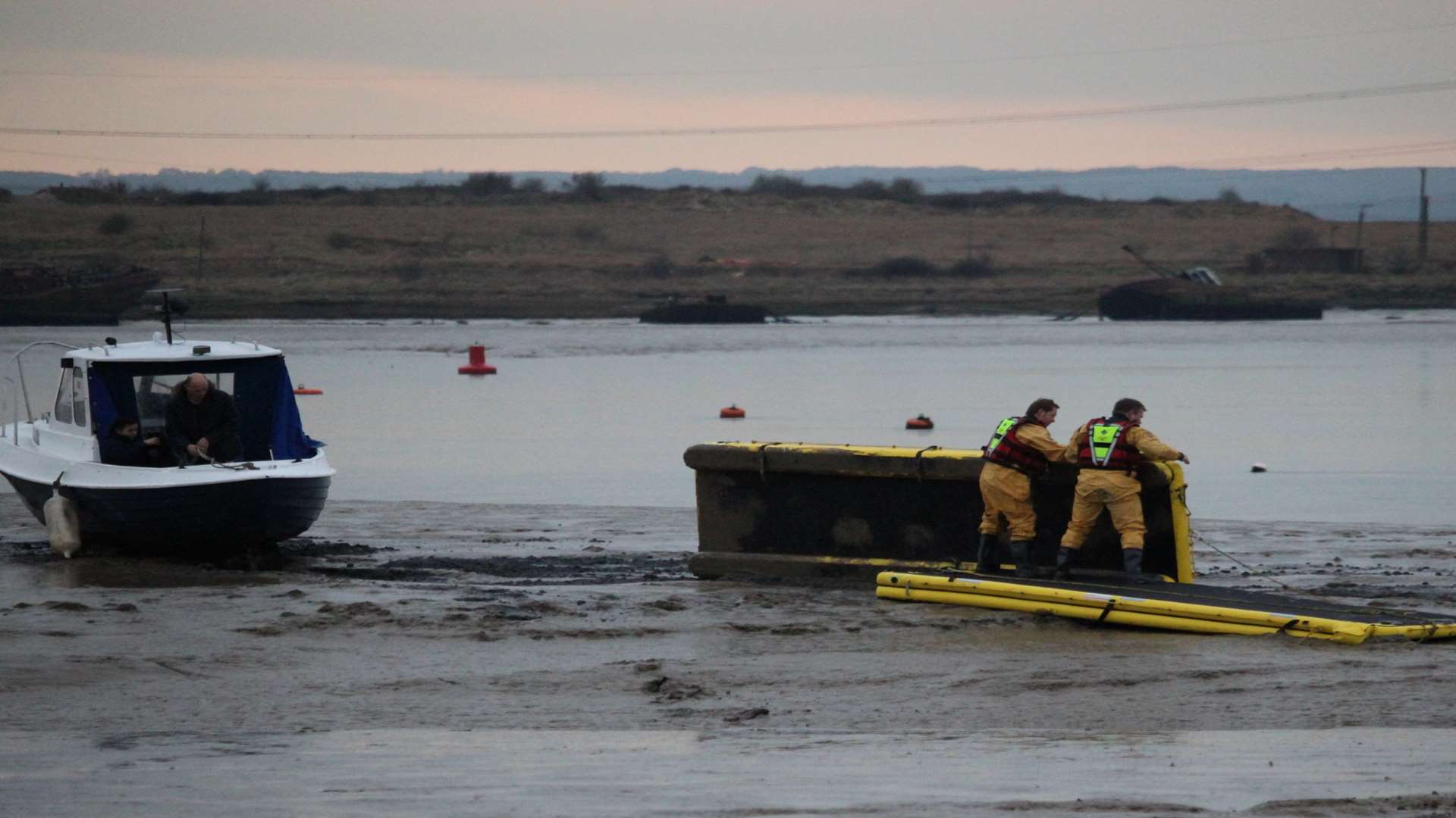 Fire-fighters heave the giant inflatable mud boards into position