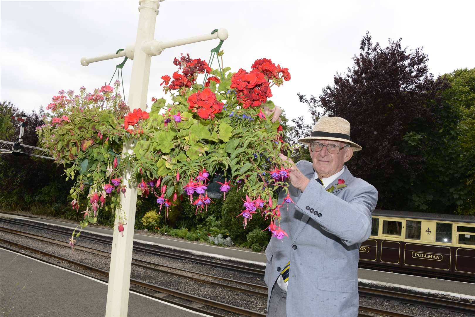 Dave Staddon, gardener at Hythe dead-heads one of the baskets