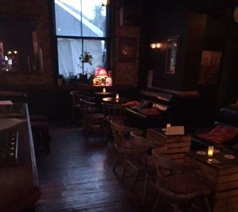 It was still light outside, but a heavy wooden floor, blue lighting and trendy lightbulbs made the inside of the bar incredibly dark