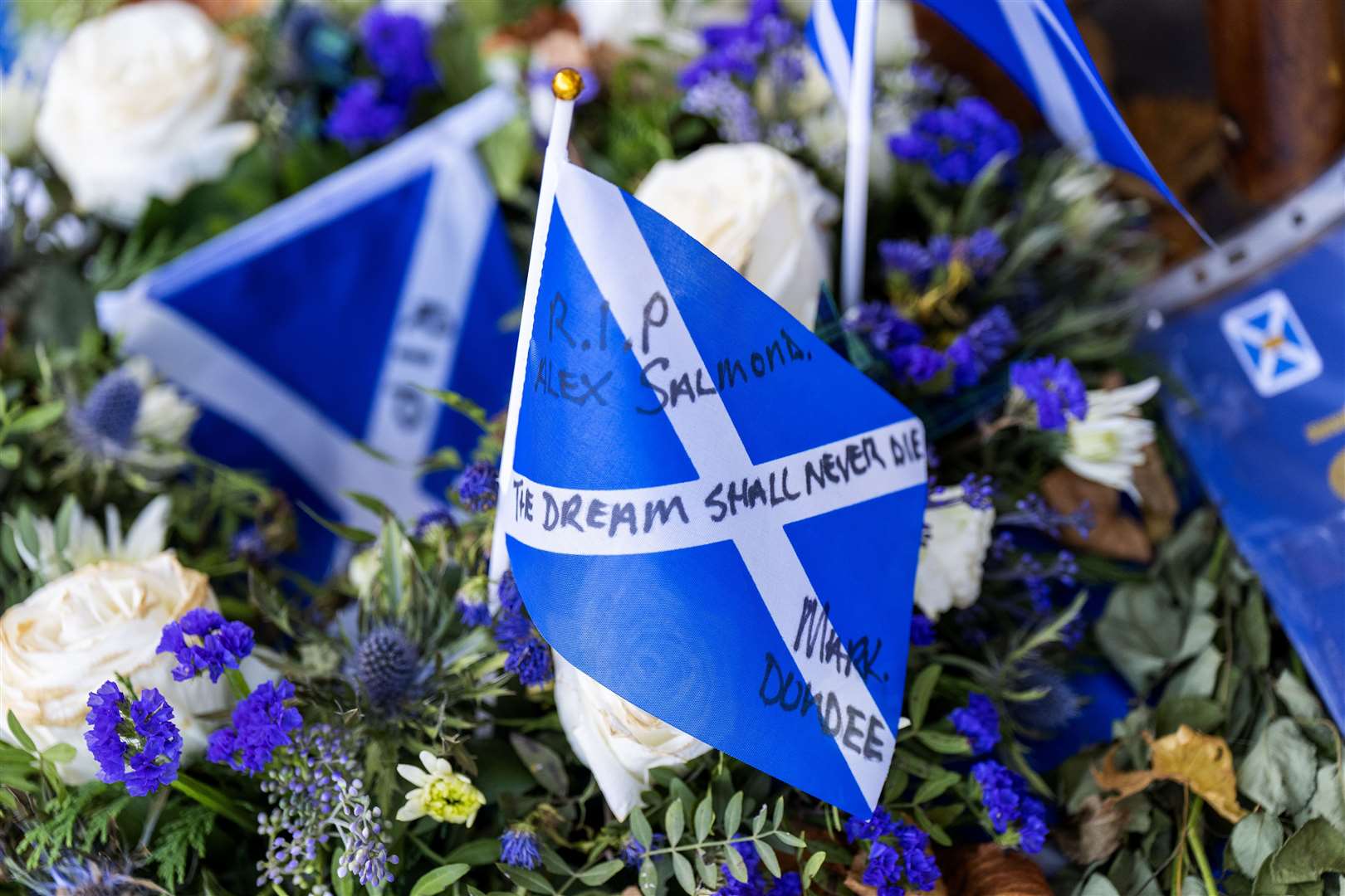 Tributes outside the Scottish Parliament building in Edinburgh ahead of a motion of condolence for the former first minister Alex Salmond (Jane Barlow/PA)