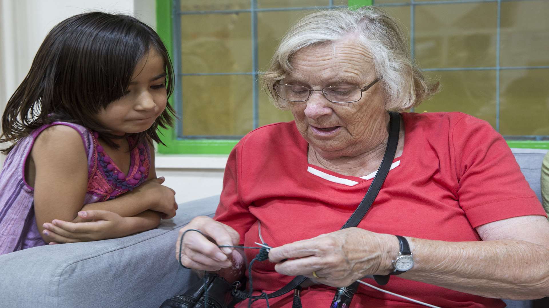 Here she shows Ghazal, aged six from Afghanistan, how to knit