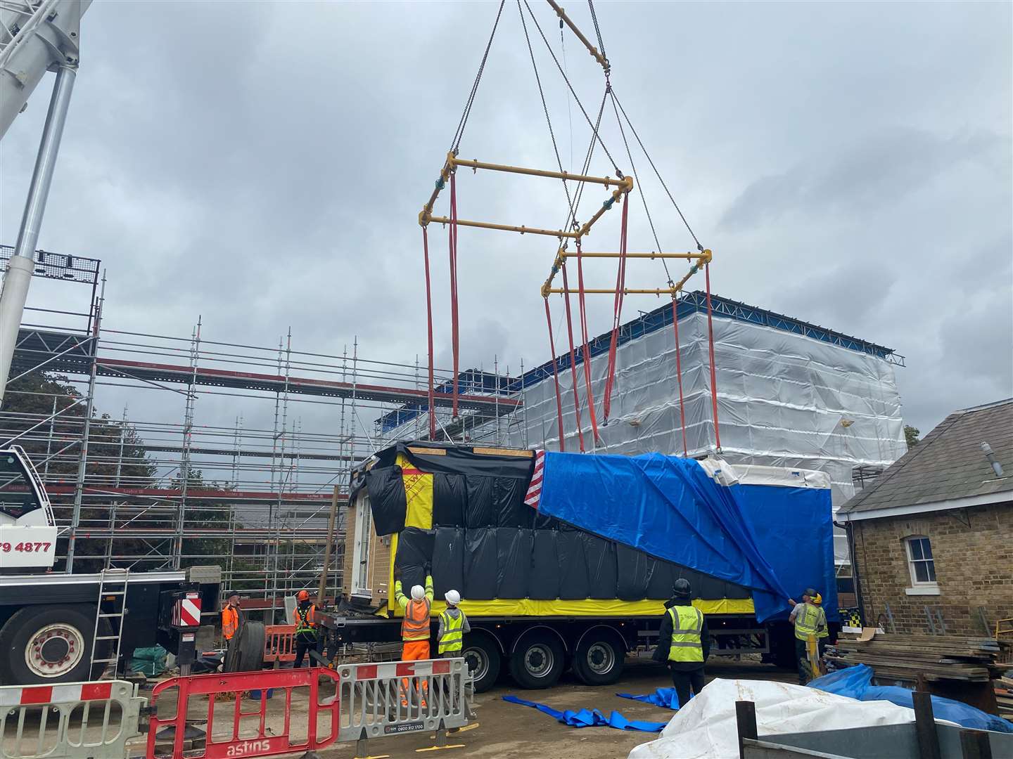 Workers attach the MMC module to the crane