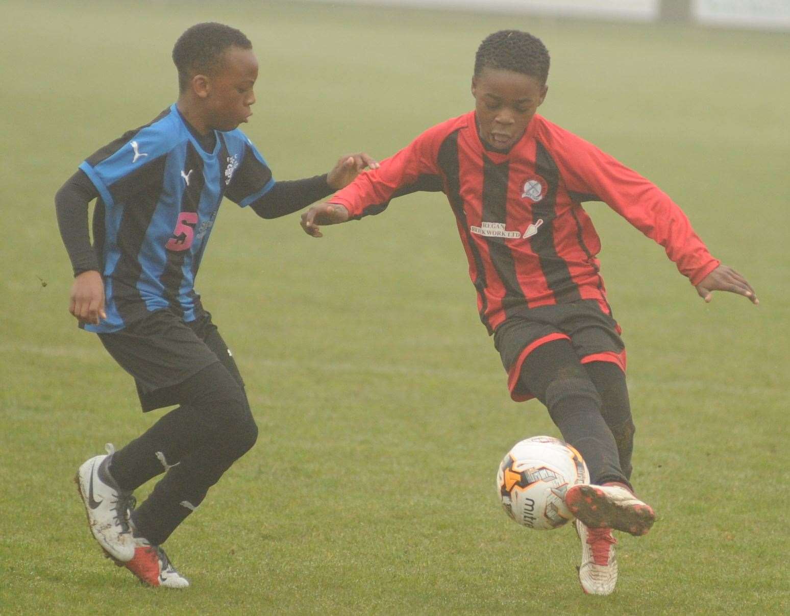 Meopham Colts Red and Omega 92 (blue/black) gets stuck in during the Under-11 Trophy Event final Picture: Steve Crispe