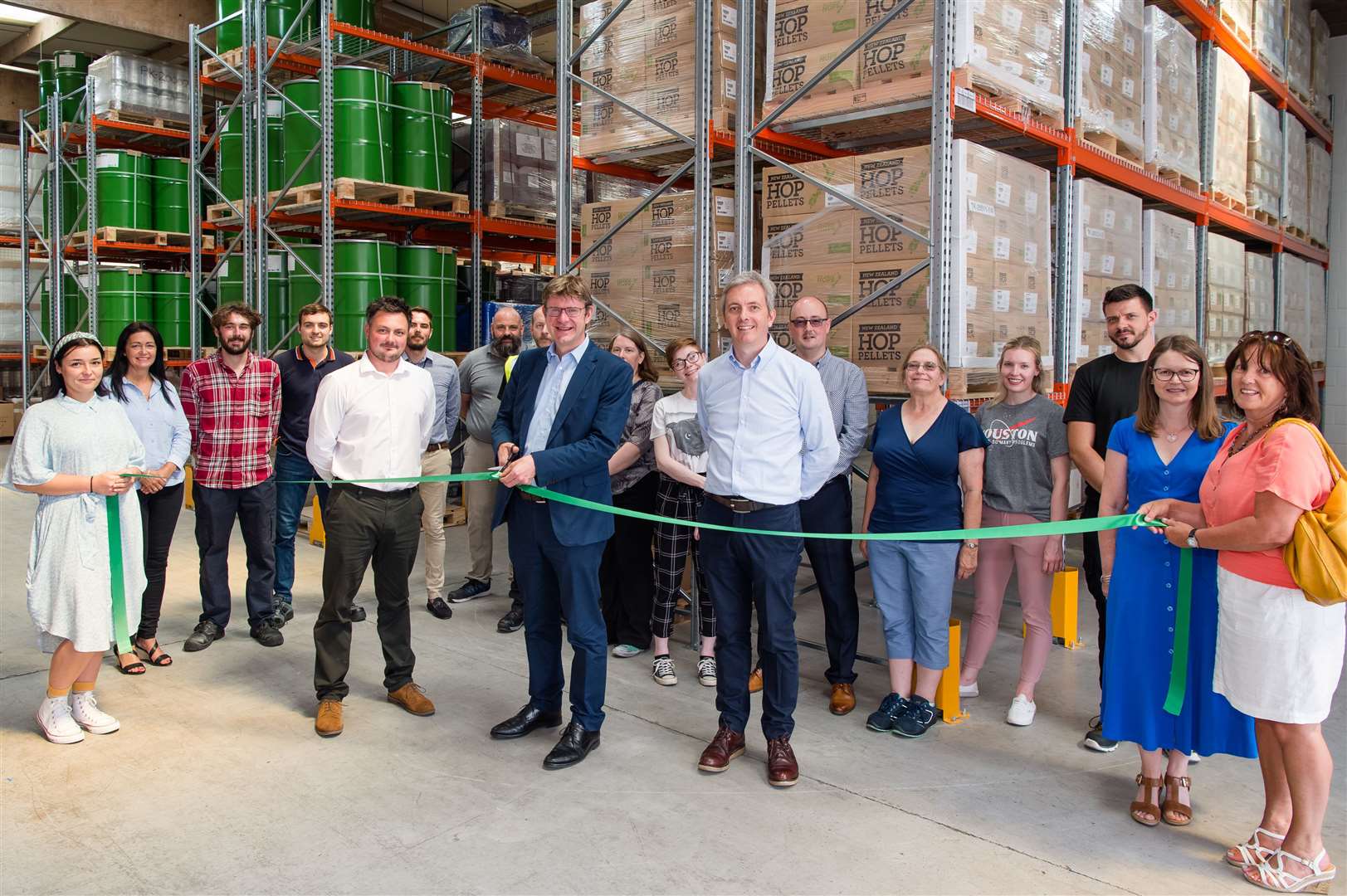 Greg Clark, MP, cuts a tape to declare the warehouse open