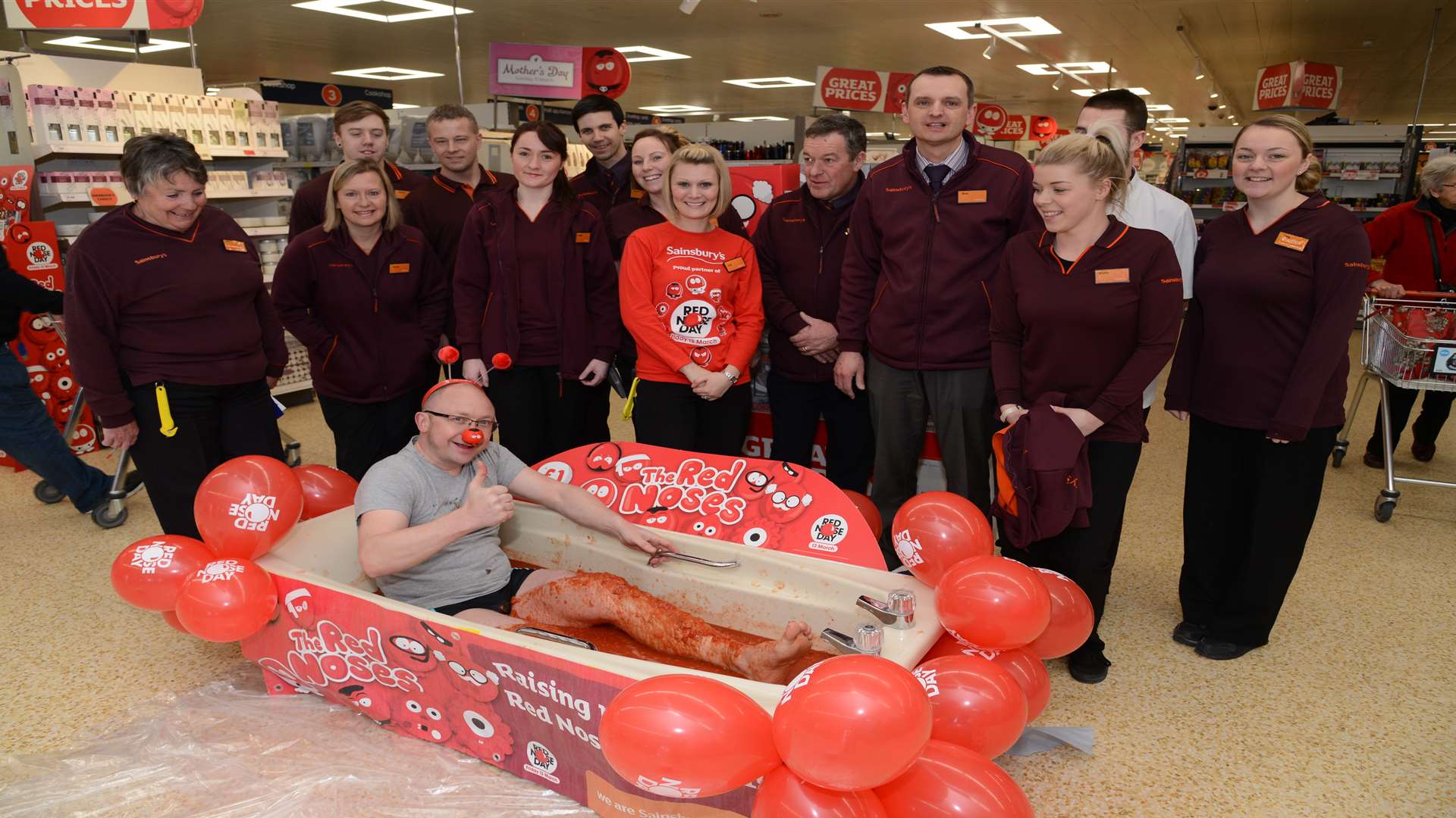 Staff at Sainsbury's support Simon Cadier as he takes a plunge in a tomato bath. Pictures: Gary Browne