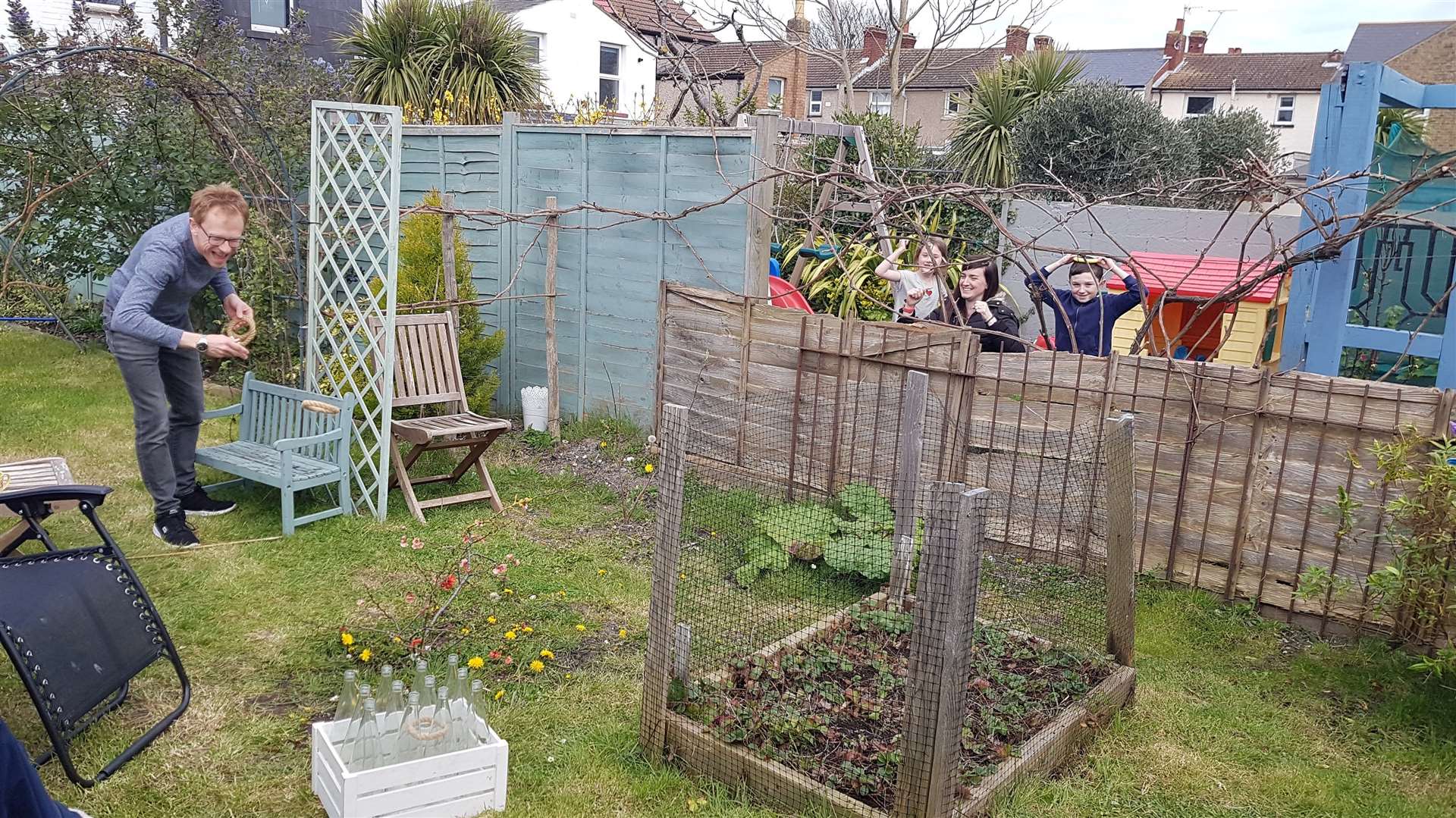 Lloyd is cheered on by the neighbours as he plays ring toss in his garden during lockdown