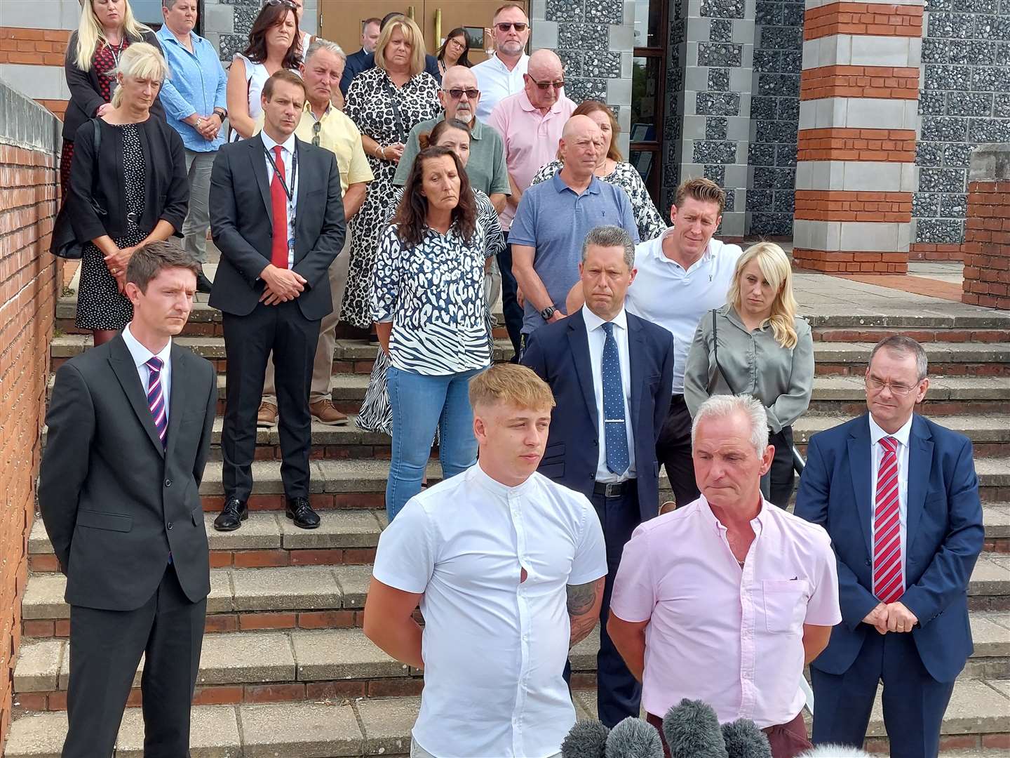 Paul James with Julia's son Patrick speaking on steps outside Canterbury Crown Court, with daughter Bethan behind