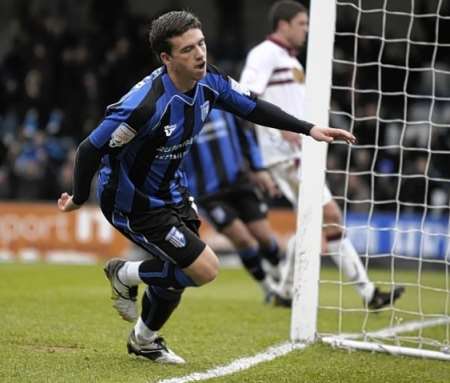 Cody McDonald tucks the ball away for Gillingham against Northampton