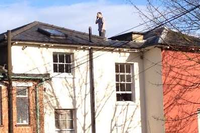 The man speaks on a mobile phone on the rooftop