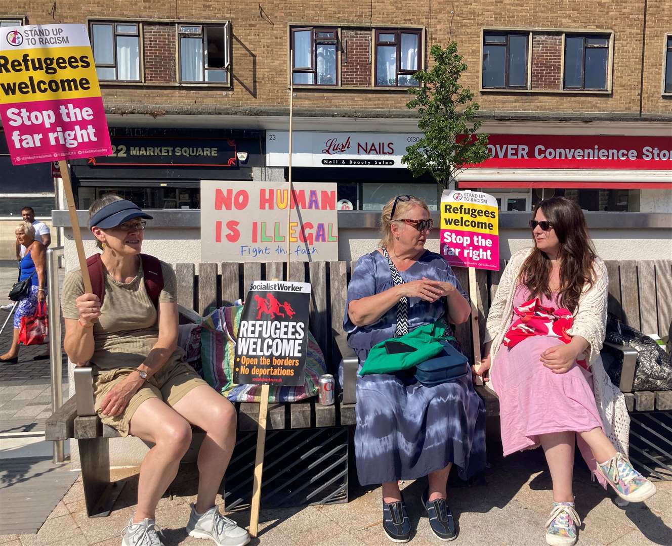 Counter-protesters with signs supporting the welcoming of refugees into the UK