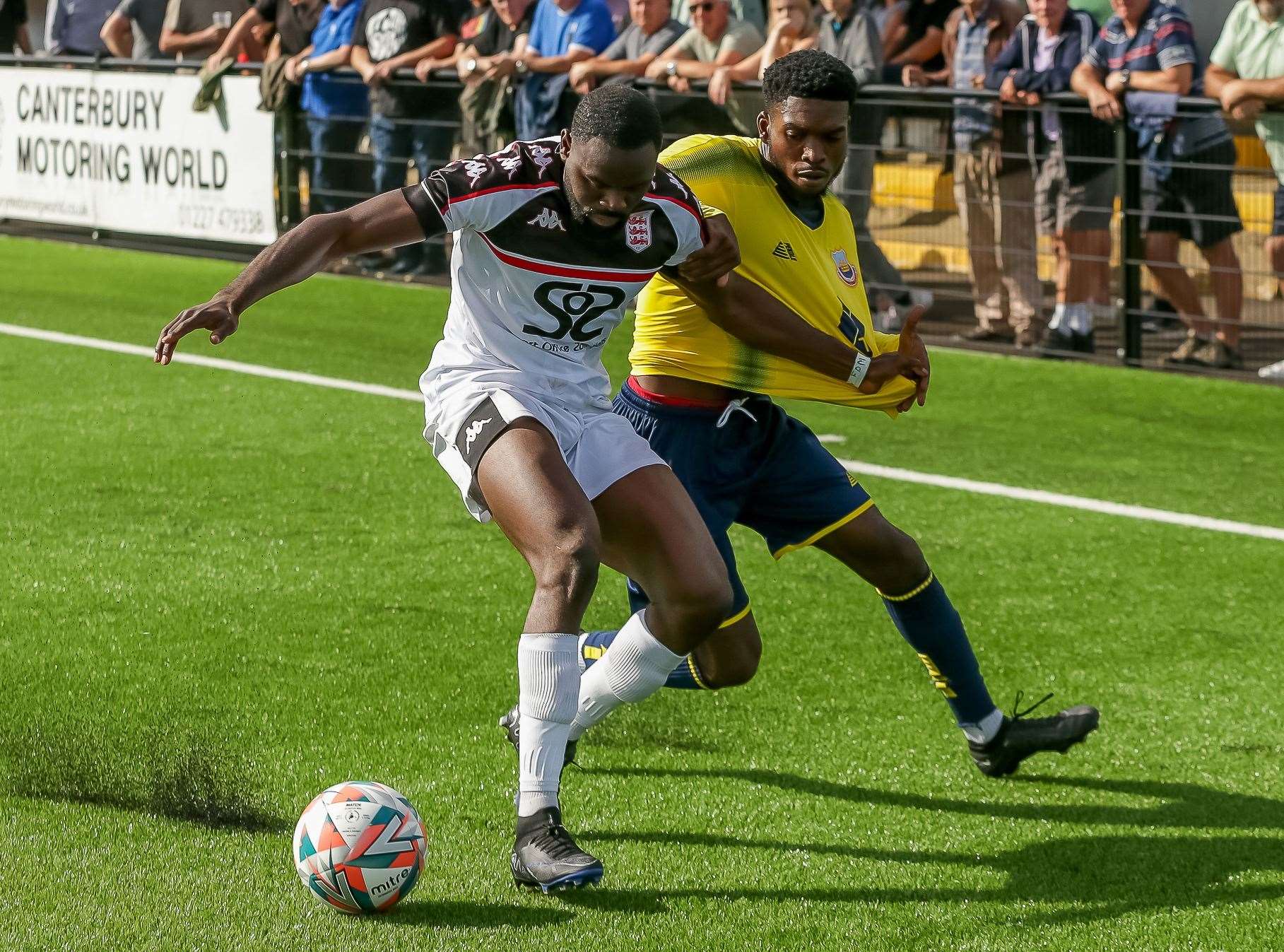 Faversham's Jacques Kpohomouh tangles with Whitstable's Eri Akintimehin at Salters Lane in the hosts’ 2-1 triumph. Picture: Les Biggs