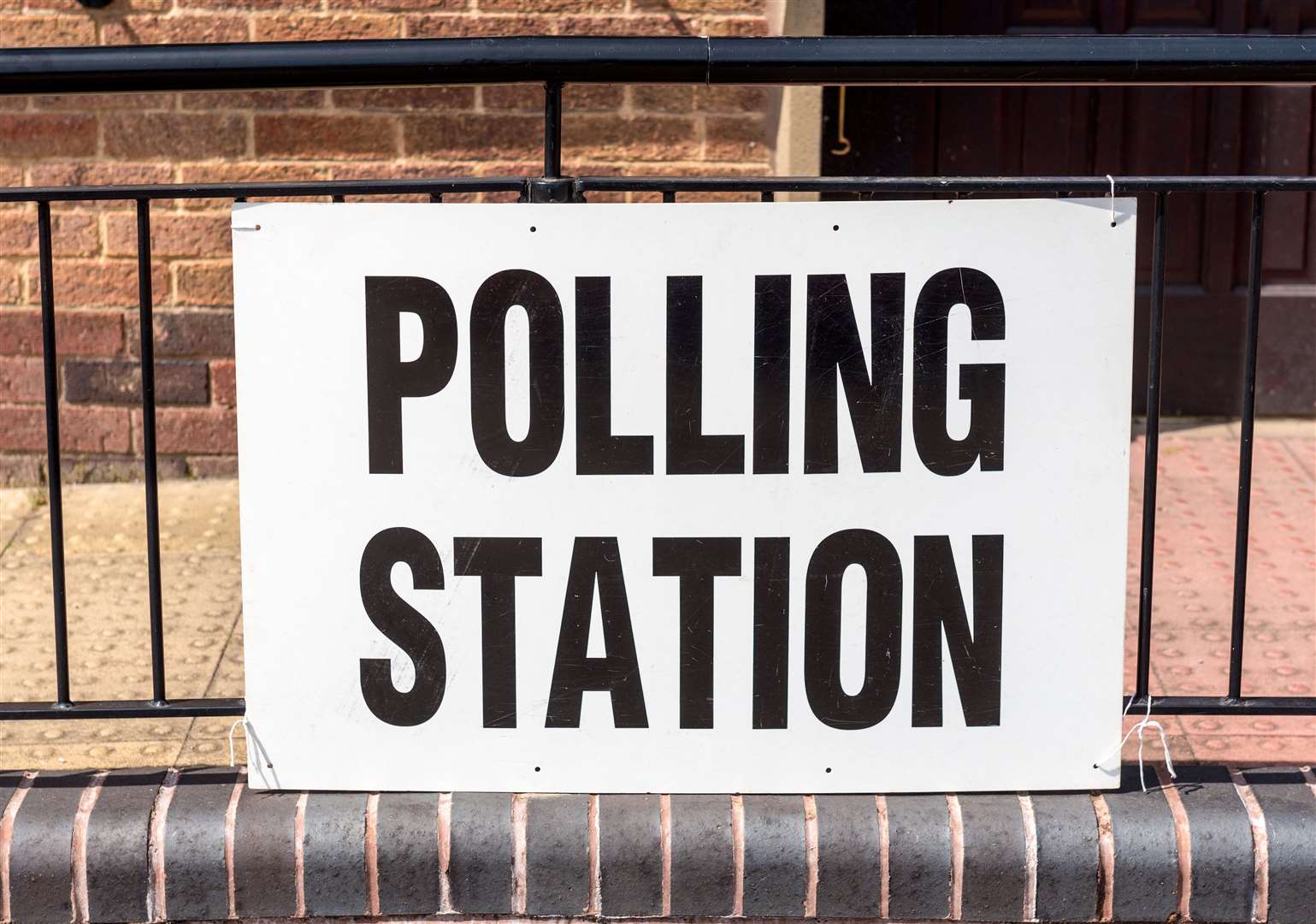 A 'Polling Station' sign outside a village hall.