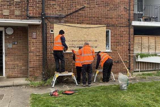 Workers placing wood board over the smashed windows. It is still there today