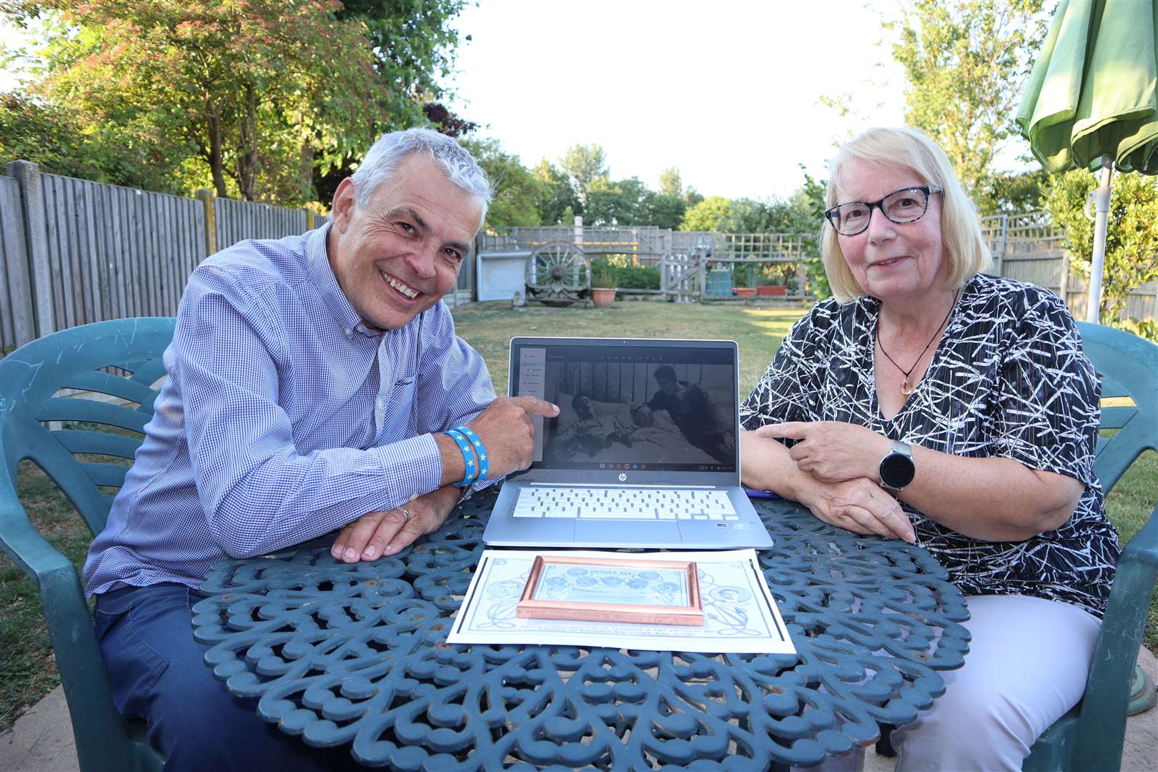 Christopher Harris of Sheerness, 61, and his cousin Therese Smith, 64, of Eastchurch study a photo of their grandfather, Sheppey coastguard Oliver Sharp. visiting recovering Boy Scout Martin Schofield, who was rescued from the capsized Arethusa sailing ship which turned turtle off Leysdown in 1912, drowning nine young boys. Picture: John Nurden