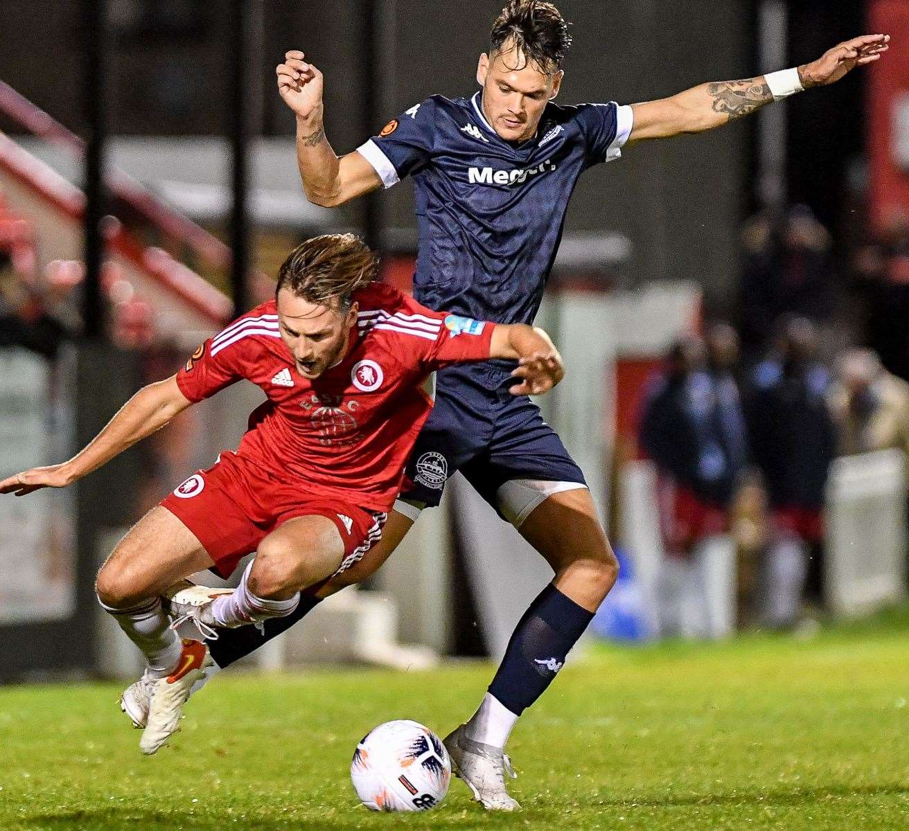 Dover's Alfie Pavey, blue, gets into a tangle with Welling's Taylor Mahoney during the sides' 1-1 draw. Picture: Dave Budden