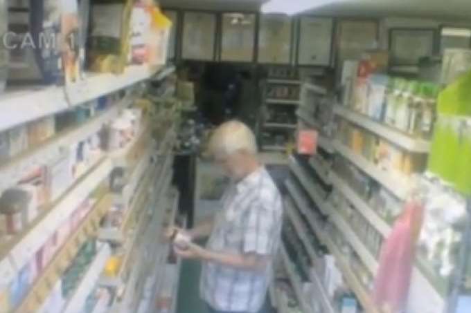 As the man looks at a product, a box of tea bags appears to levitate from a shelf behind him