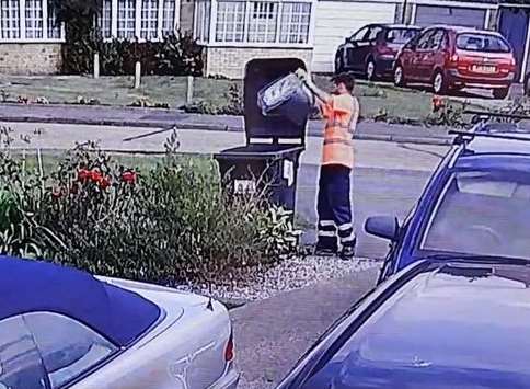 The worker is seen tipping recycling into a waste bin