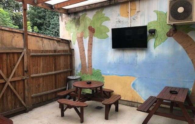 When I couldn’t find anyone behind the bar I looked at the back of the pub and found this covered seating area with a tropical island painted on one wall