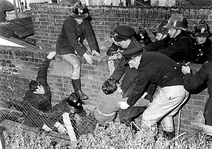 Fire crews help a colleague after he was lowered down the hole to try and rescue Jean Thompson. Picture: Roger Johnson