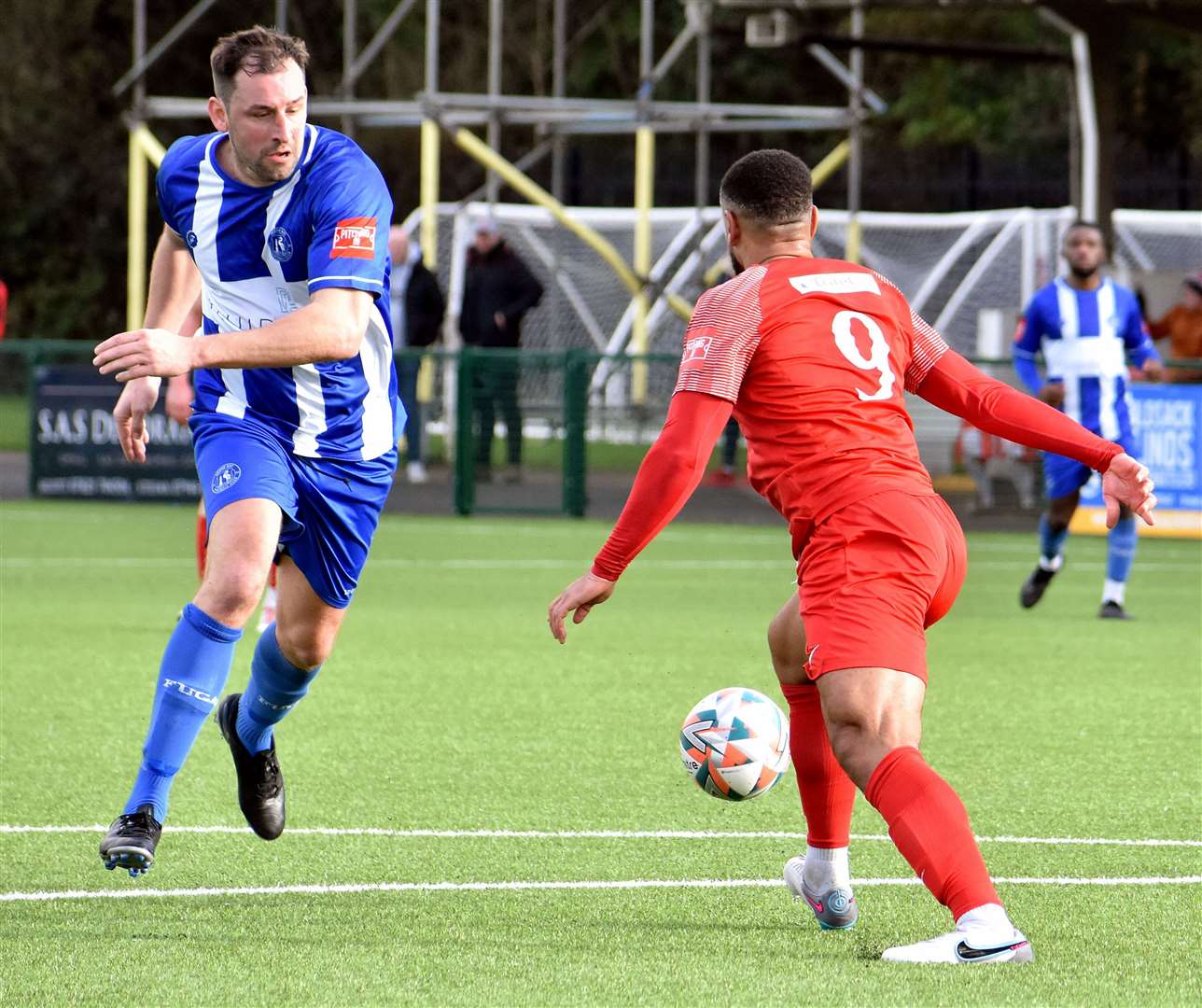 Herne Bay player-coach Liam Friend, who later saw red, comes up against Hythe’s Johan Caney-Bryan. Picture: Randolph File