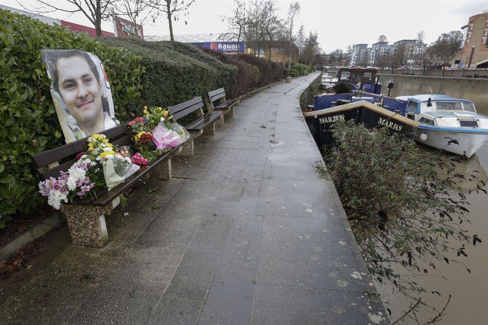 Floral tributes for Pat Lamb are placed on a bench