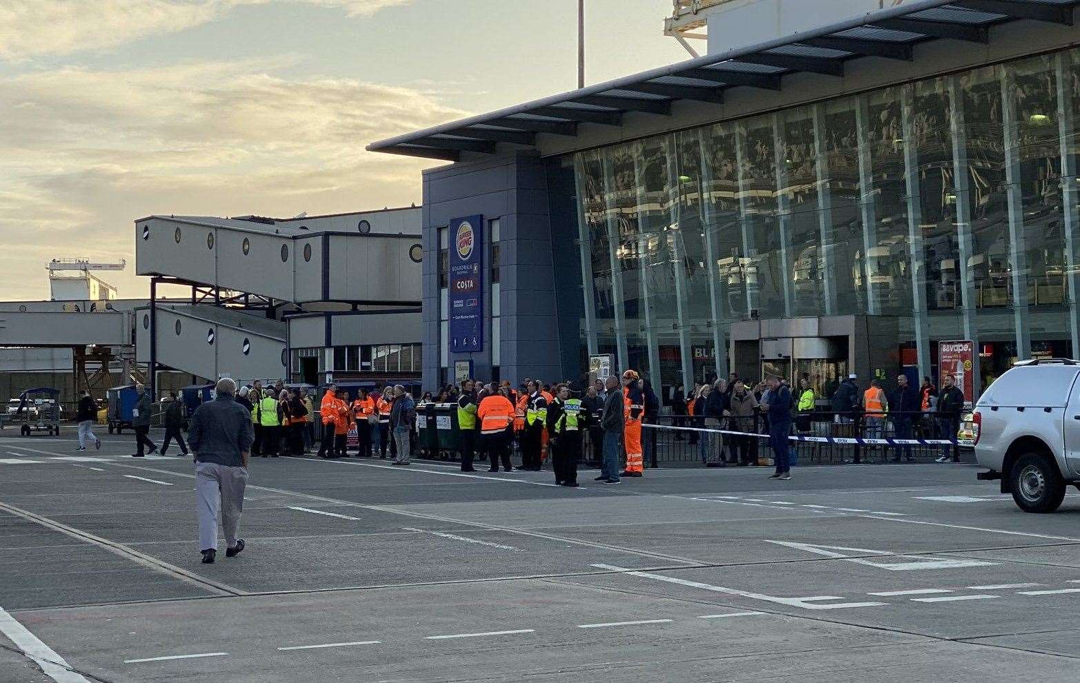 People can be seen waiting outside one of the port's buildings. Picture by @courier_michael