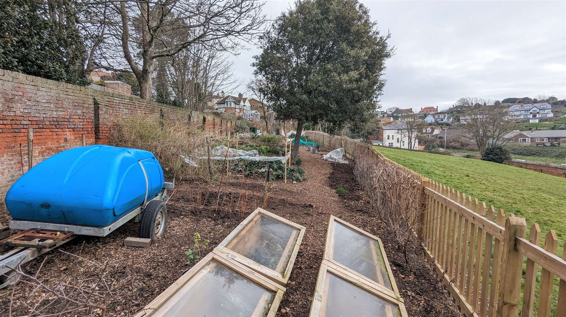 Volunteers tend a community garden at Enbrook Park