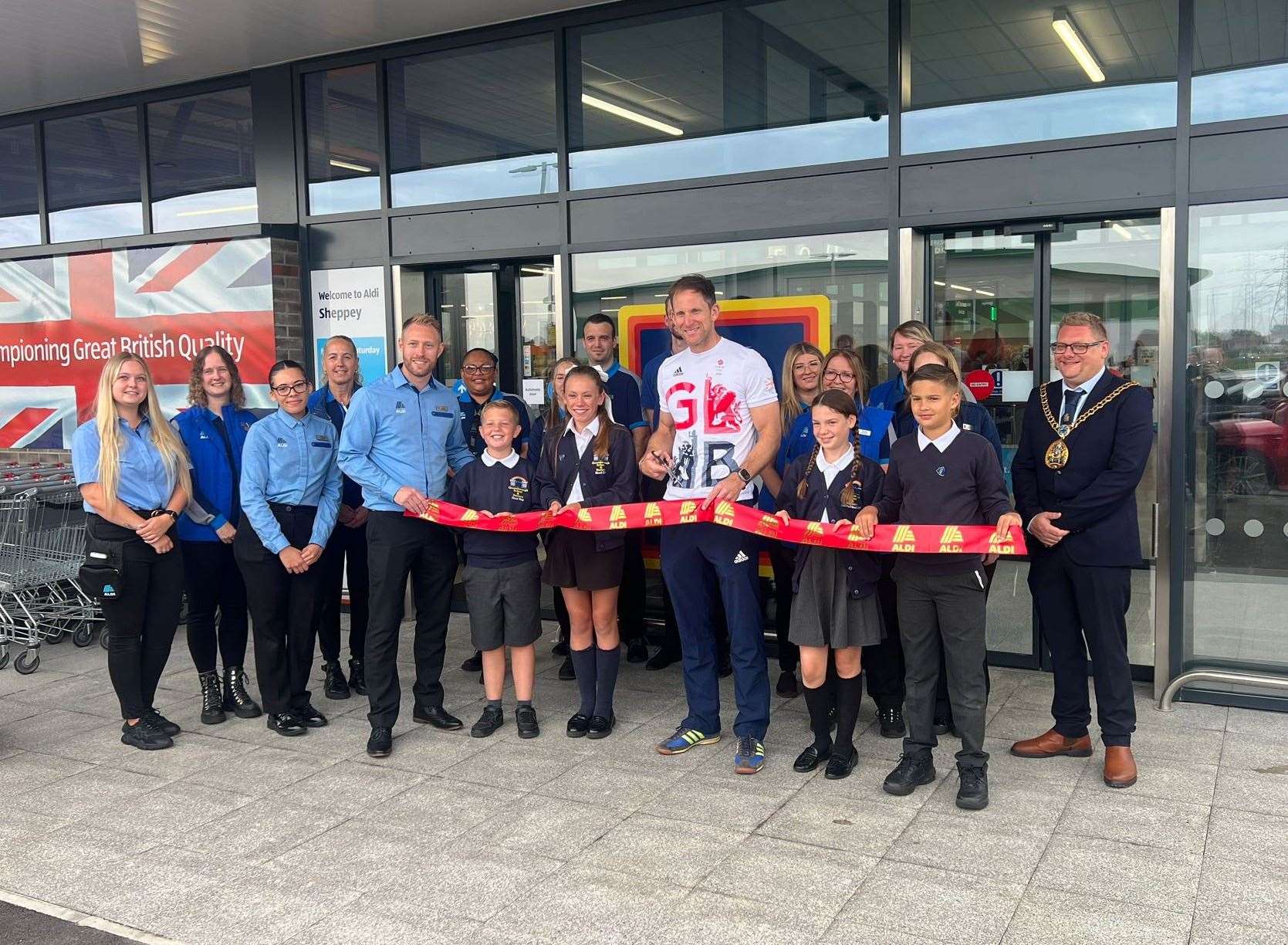 Olympian Matt Langridge cutting the ribbon with staff and pupils from Queenborough Primary and Nursery and the Mayor of Swale, Cllr Ben Martin