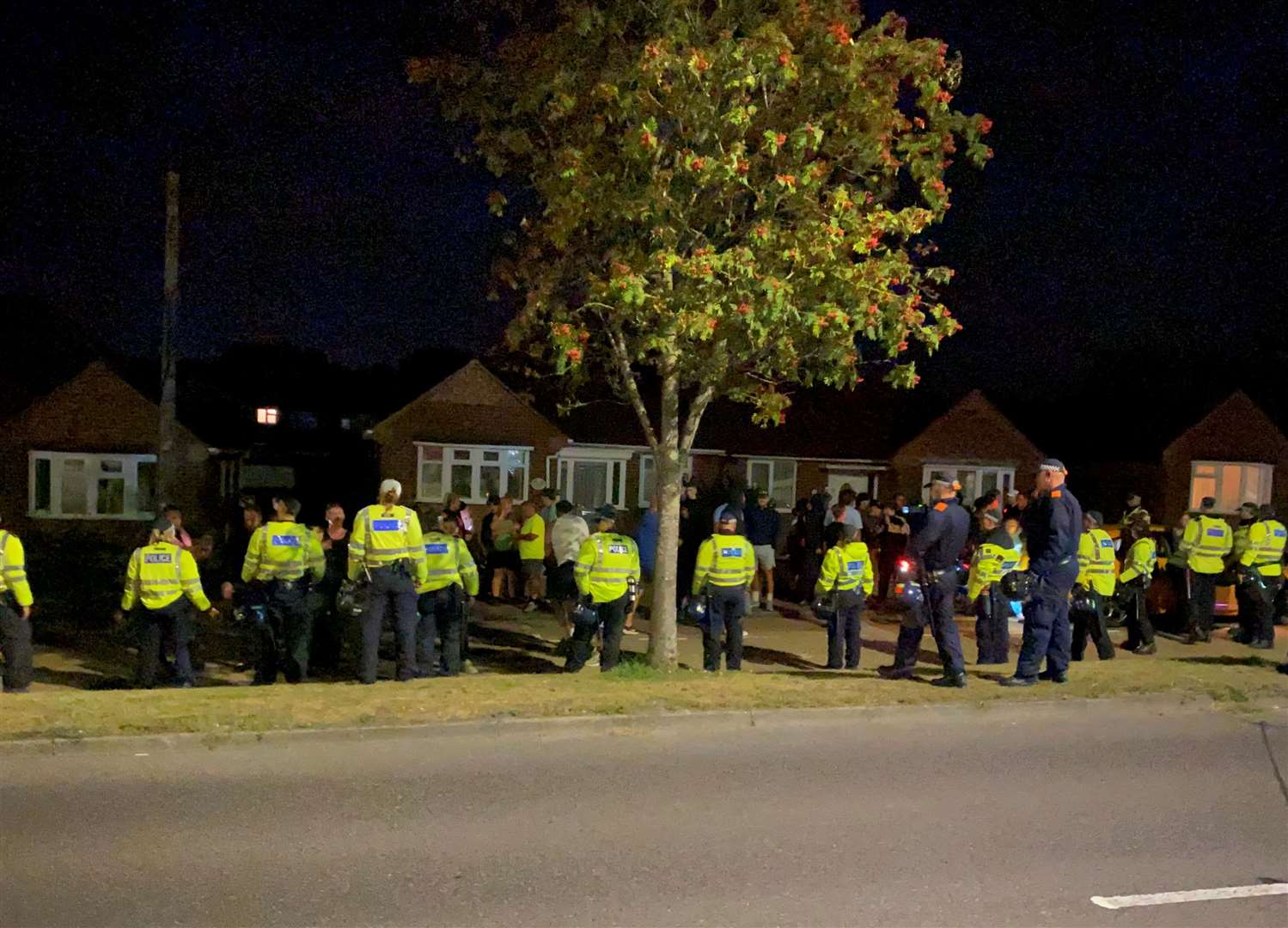 Police officers start to move on people who have gathered outside the Innovation Centre