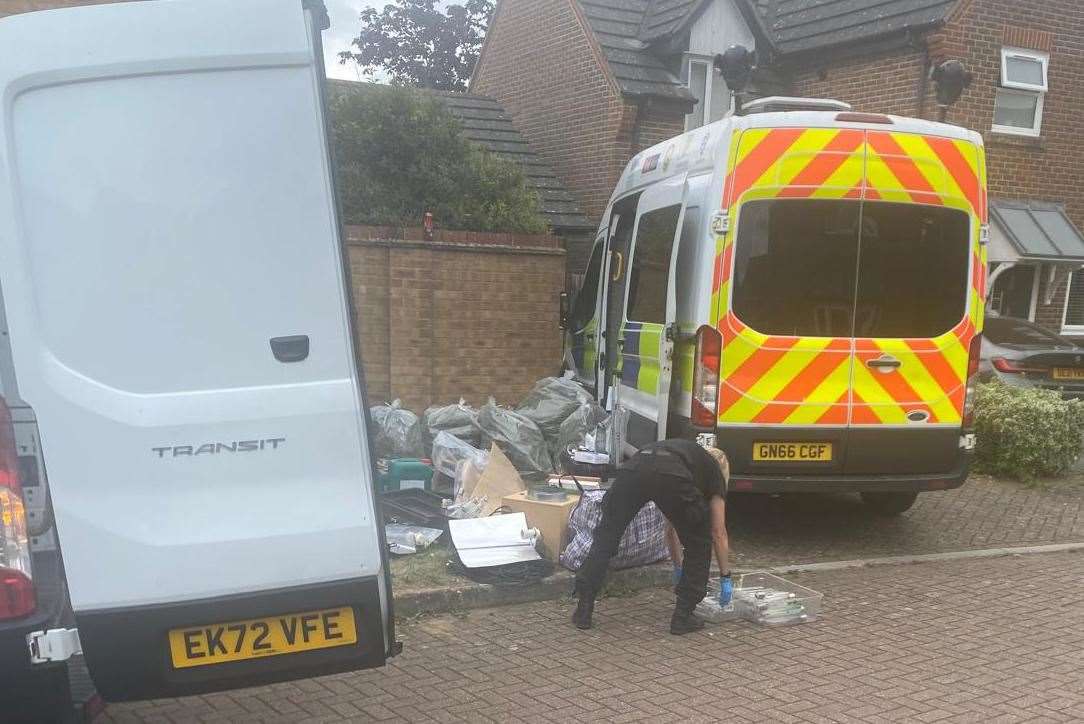 Police were seen riffling through household items and waste from a property in Wood Lane, Ashford