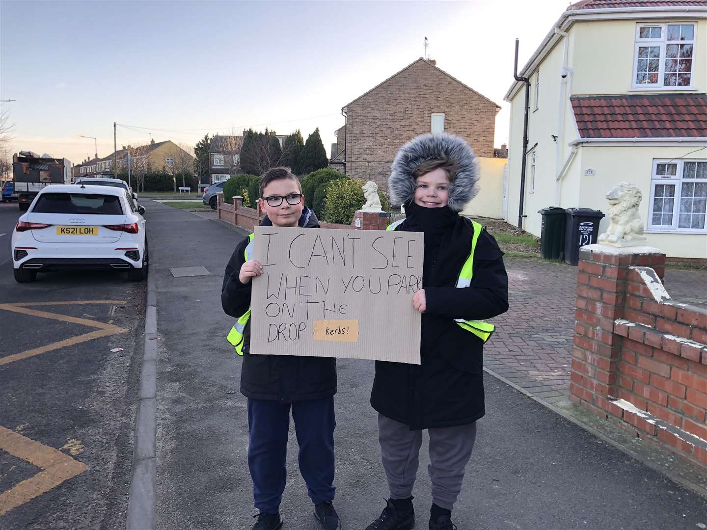 The children held hand-written signs saying they could not see when crossing