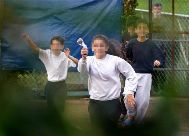 A young girl ran to the fence around Manston migrant processing centre to throw a message in a bottle to a PA news agency photographer. Photo: Gareth Fuller/PA