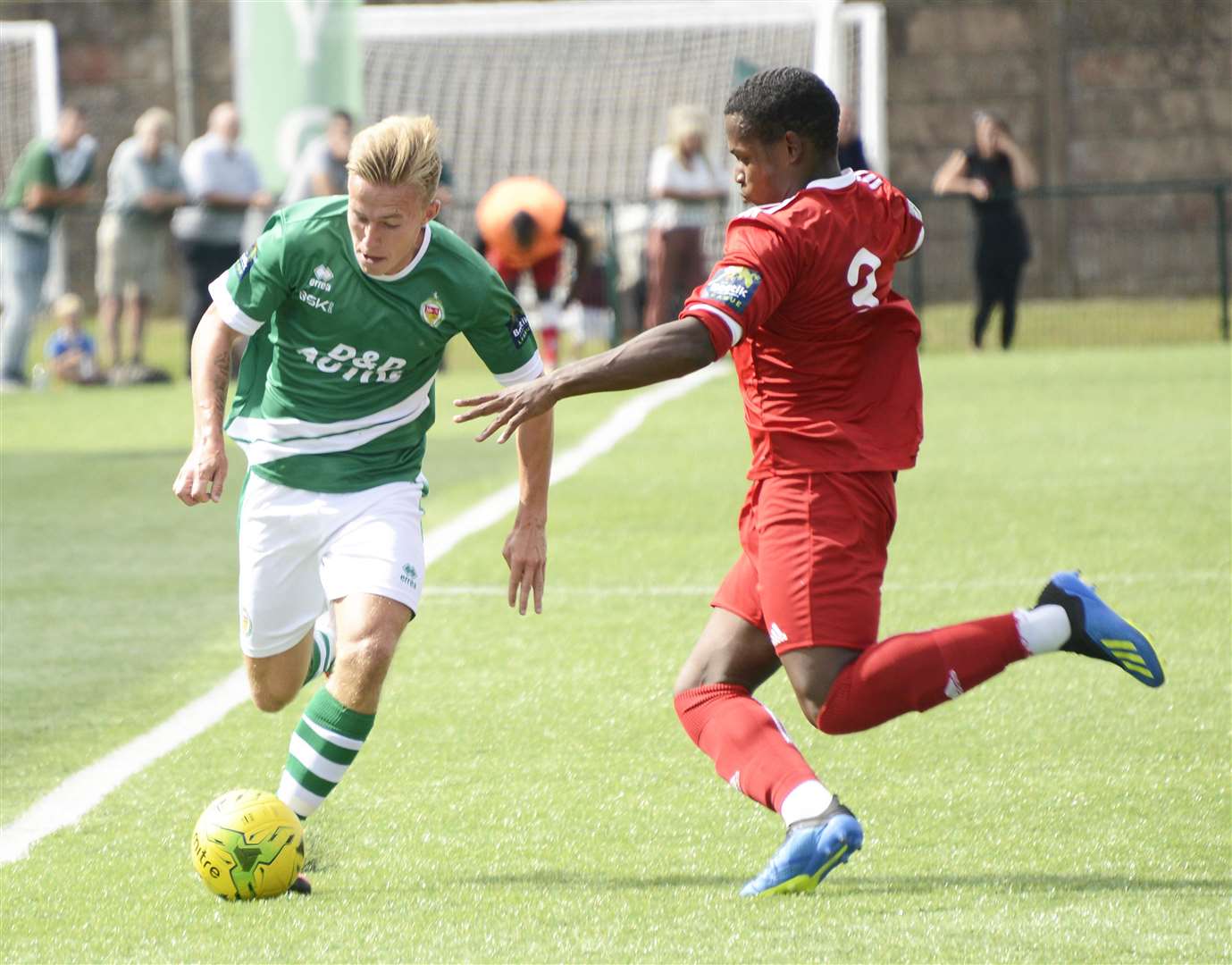 Ashford man Sam Corne (green) gets down the line against Hythe Picture: Paul Amos