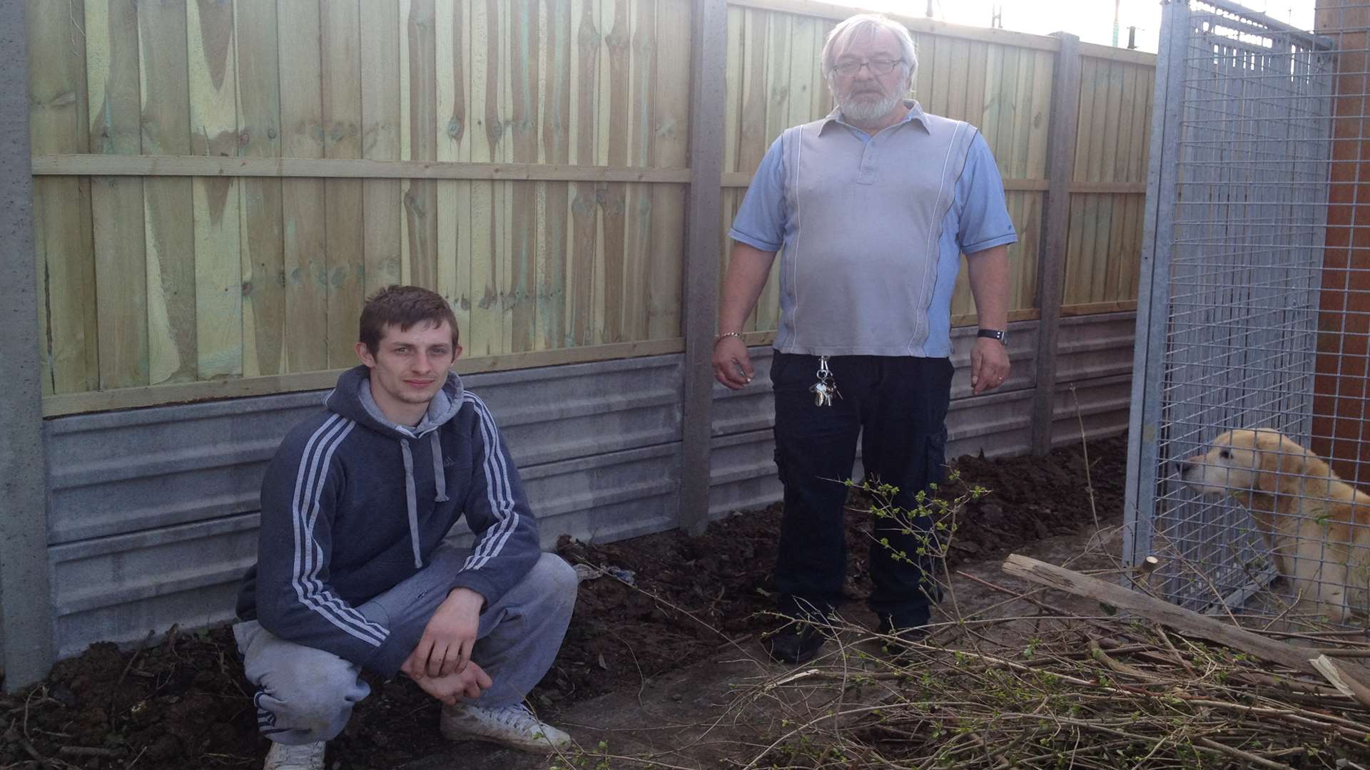 Casey Gleed and Roger Griffin next to the fence panel where the grenade was found