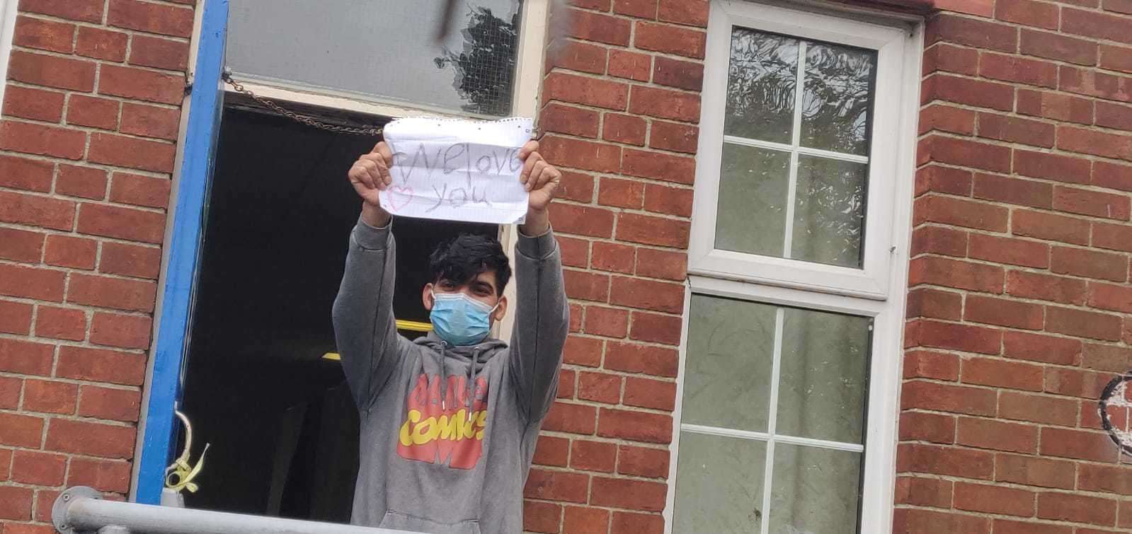 A refugee holds up a 'we love you' sign Picture: Rhys Griffiths