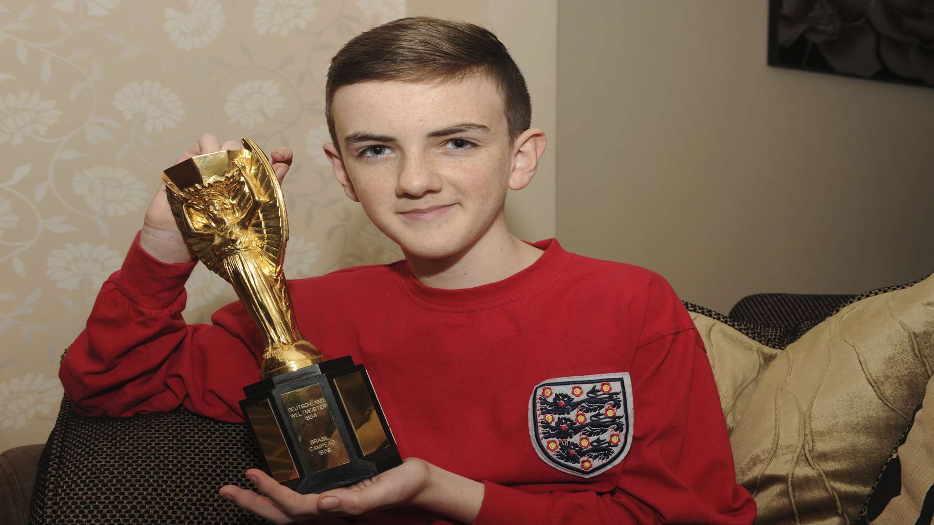 Jonjo Heuerman is the youngest person to receive the British Empire Medal. With replica Jules Rimet World Cup football trophy. Picture: Steve Crispe