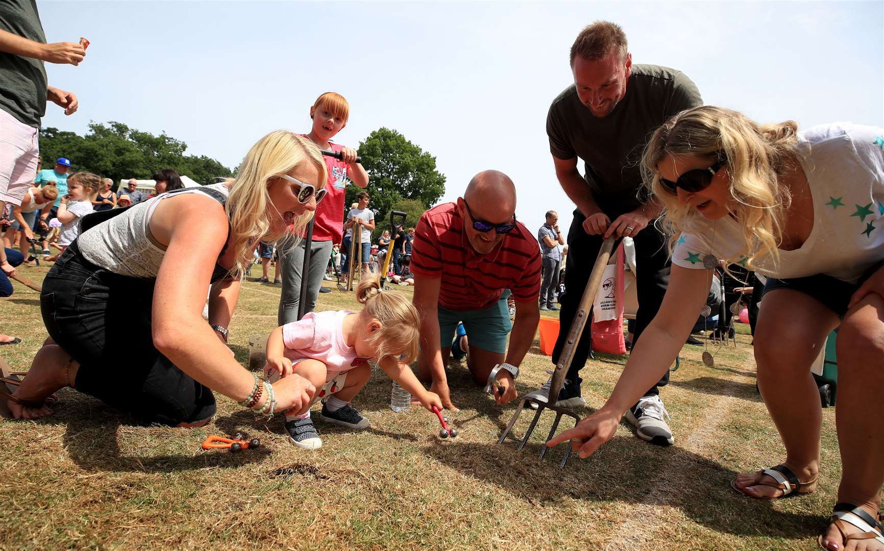 Competitors try to coax the most worms out of the ground during the World Worm Charming Championships at Willaston County Primary School, in Willaston, Nantwich, Cheshire (PA)