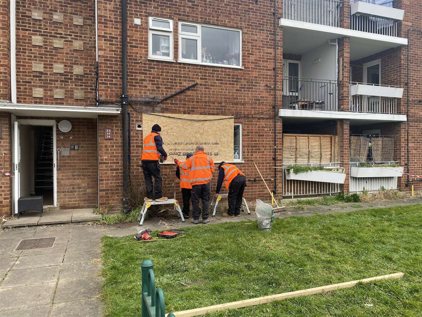 Workers boarding up the blown-out windows the day after the explosion