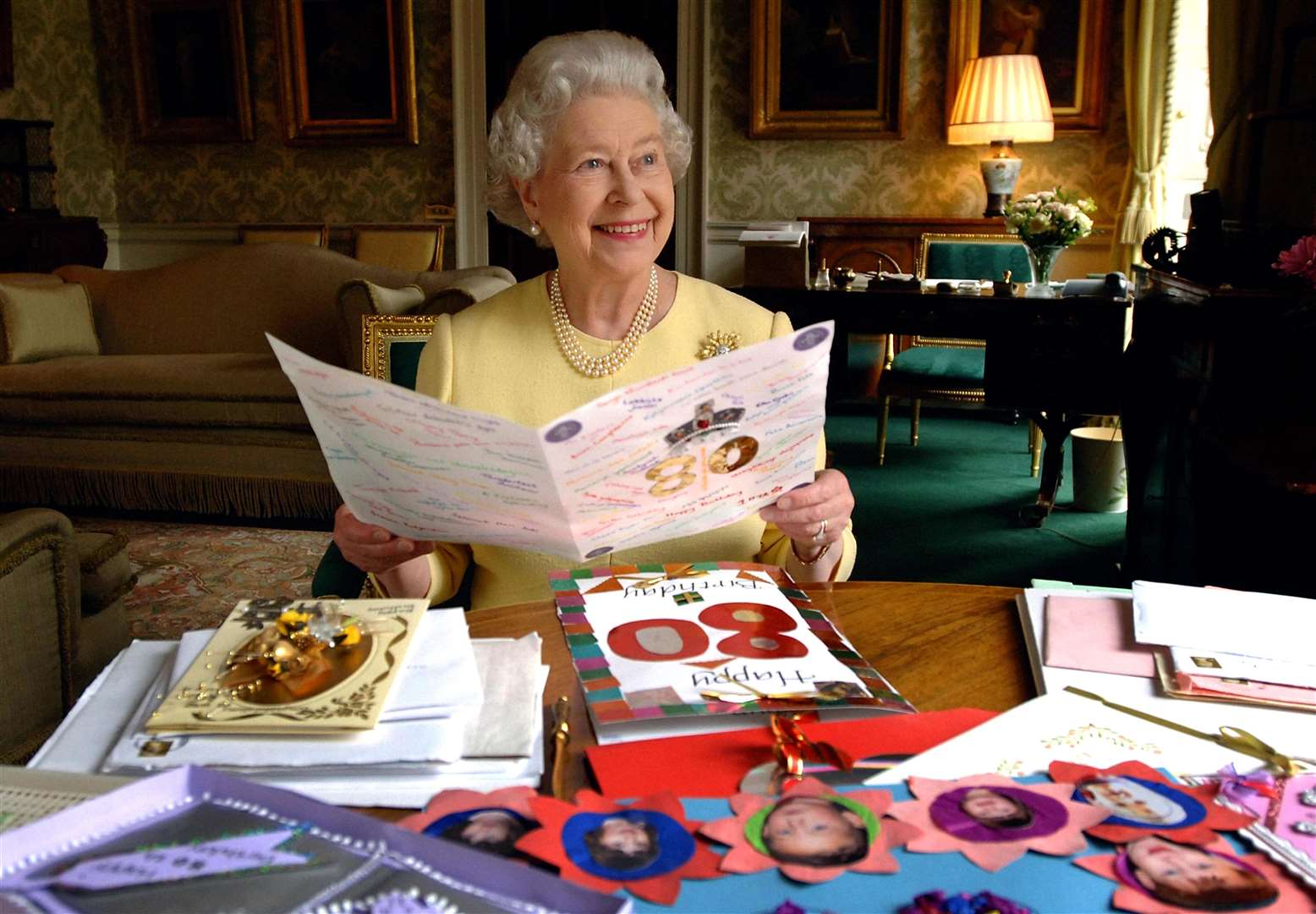 The Queen at Buckingham Palace looks at some of her 80th birthday cards in 2006 (Fiona Hanson/PA)