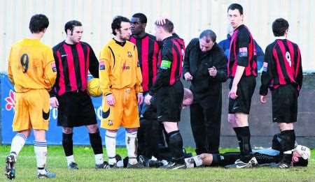 Sittingbourne keeper Deren Ibrahim receives attention after the second-half challenge by Folkestone's Simon Austin