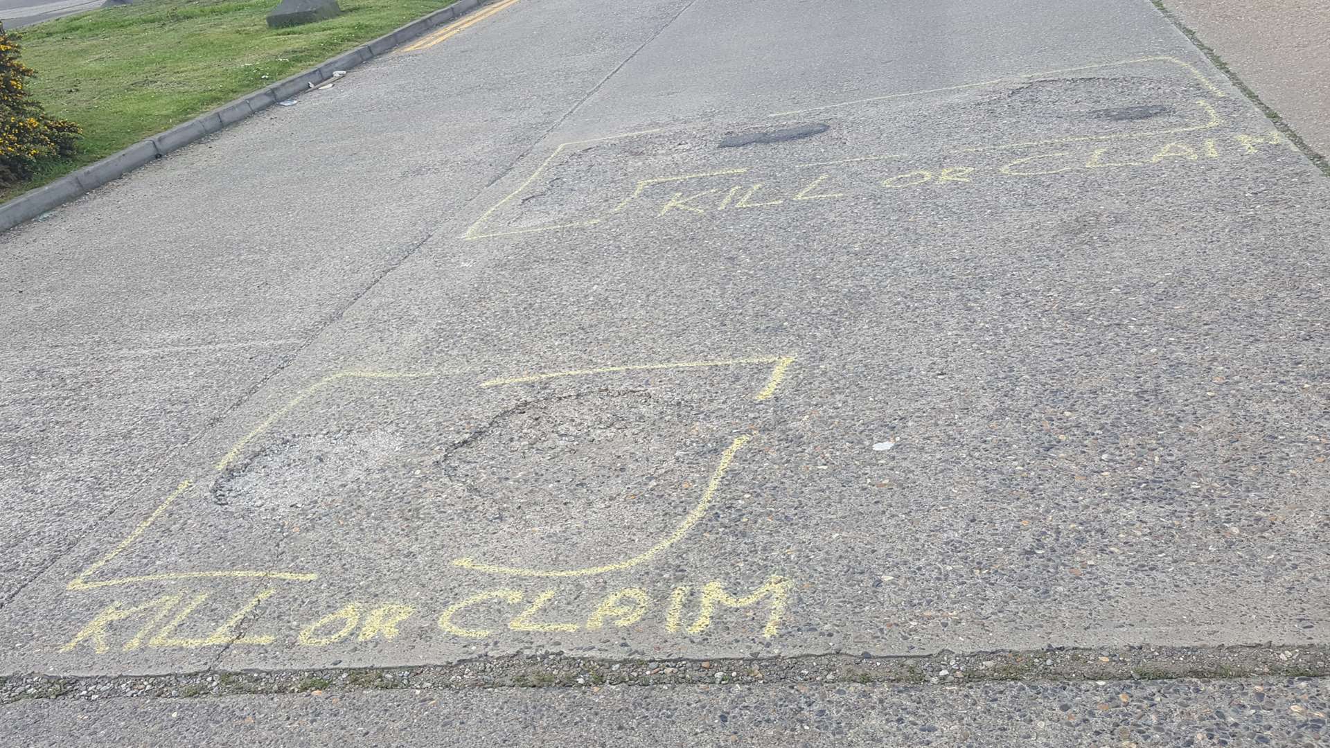 Two large potholes on Enterprise Way have been labelled with words saying 'KILL OR CLAIM'