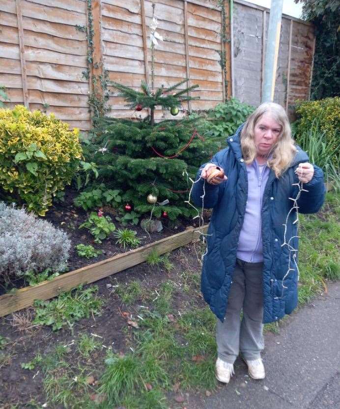 Susan Hogg holds up the vandalised Christmas tree lights