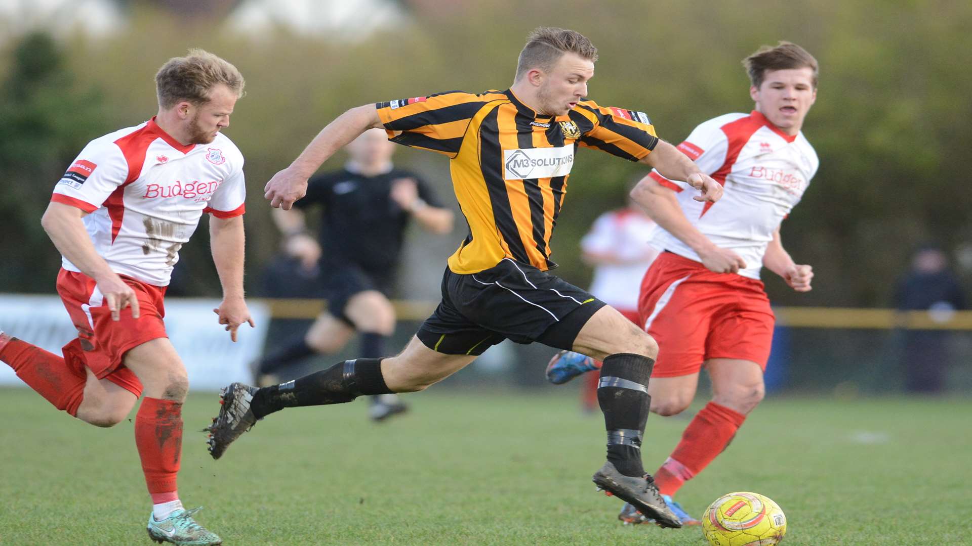 Jon Pilbeam takes on two Whitstable Town players Picture: Gary Browne