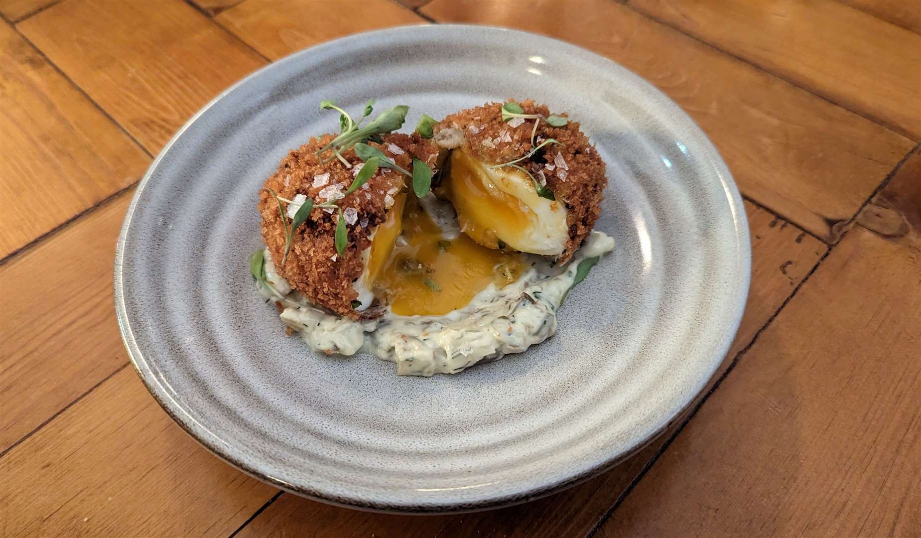 Cutting the smoked haddock scotch egg reveals the oozing yolk