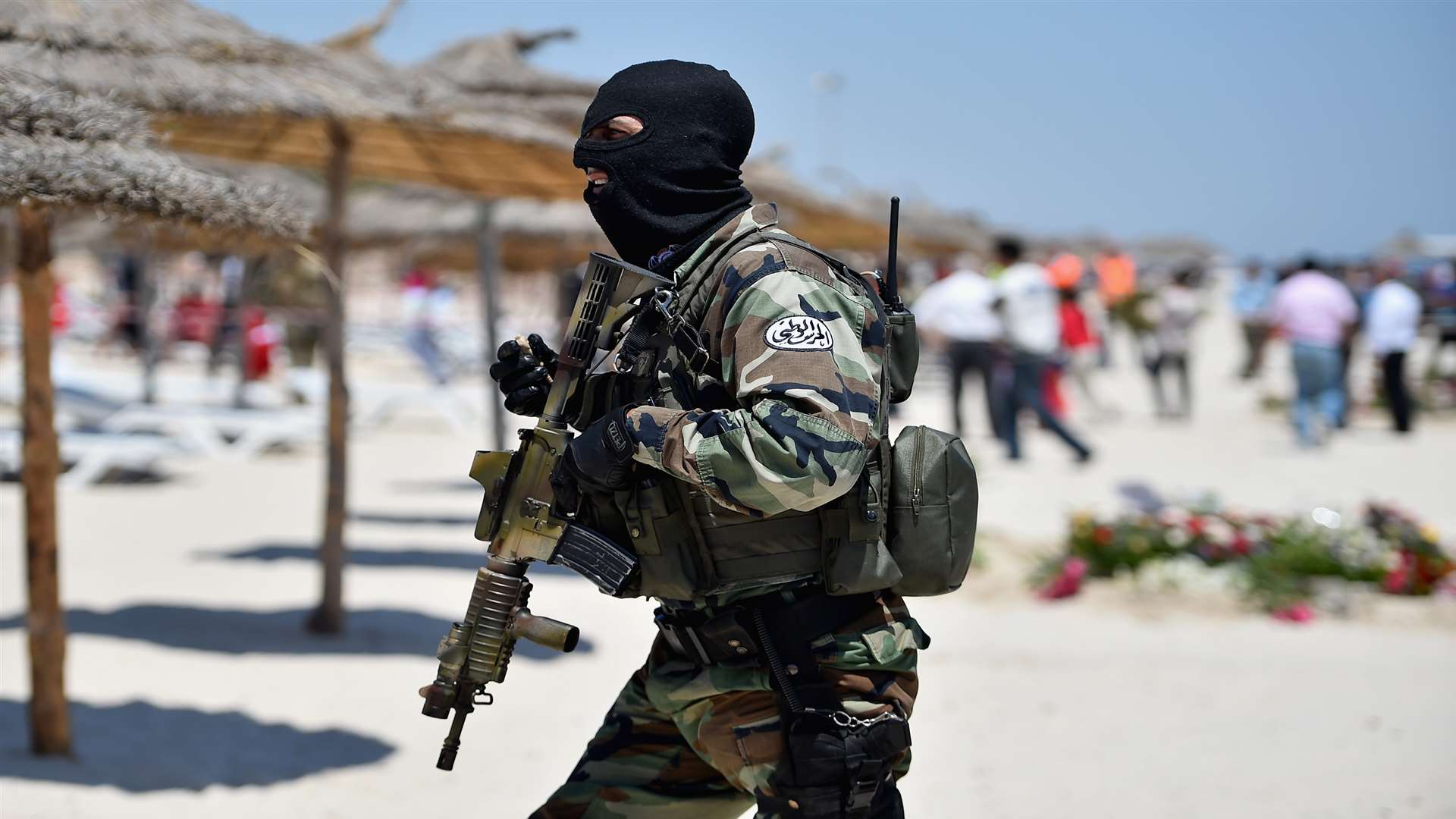 Armed guards patrol Marhaba beach during a visit by British Home Secretary Theresa May at the scene where 38 people were killed last Friday