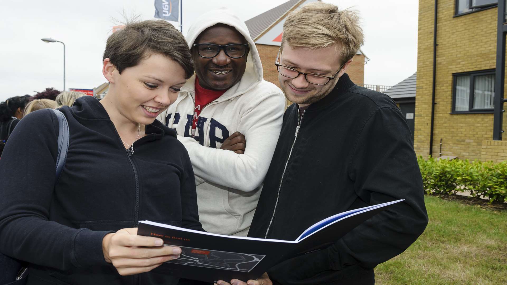 Sarah Wallin, Fem Yussuf and Joel Swift look at the Bellway brochure in the queue.