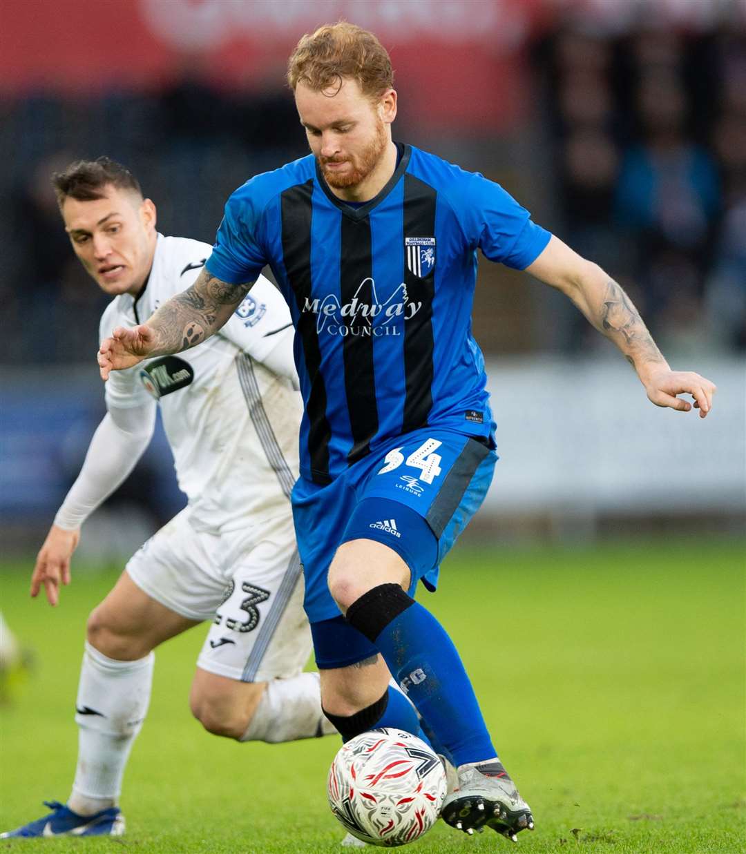 Connor Ogilvie tries to play the ball out of defence watched by Connor Roberts Picture: Ady Kerry