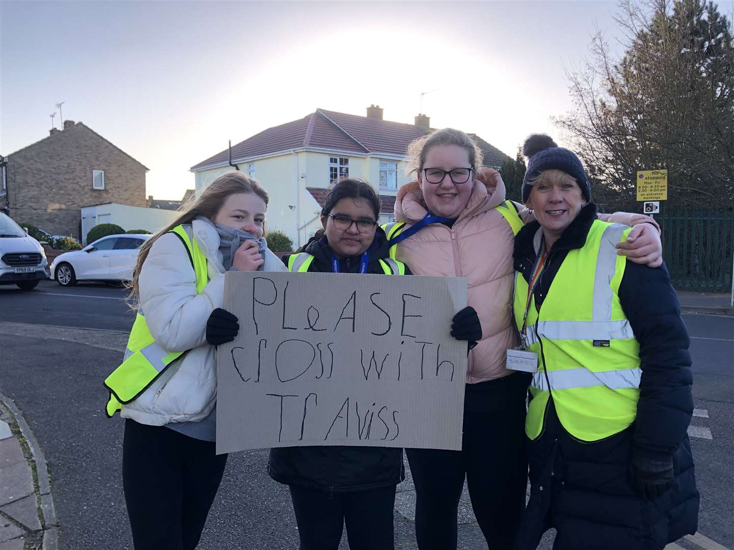 They are asking everyone to cross with the school's lollipop man