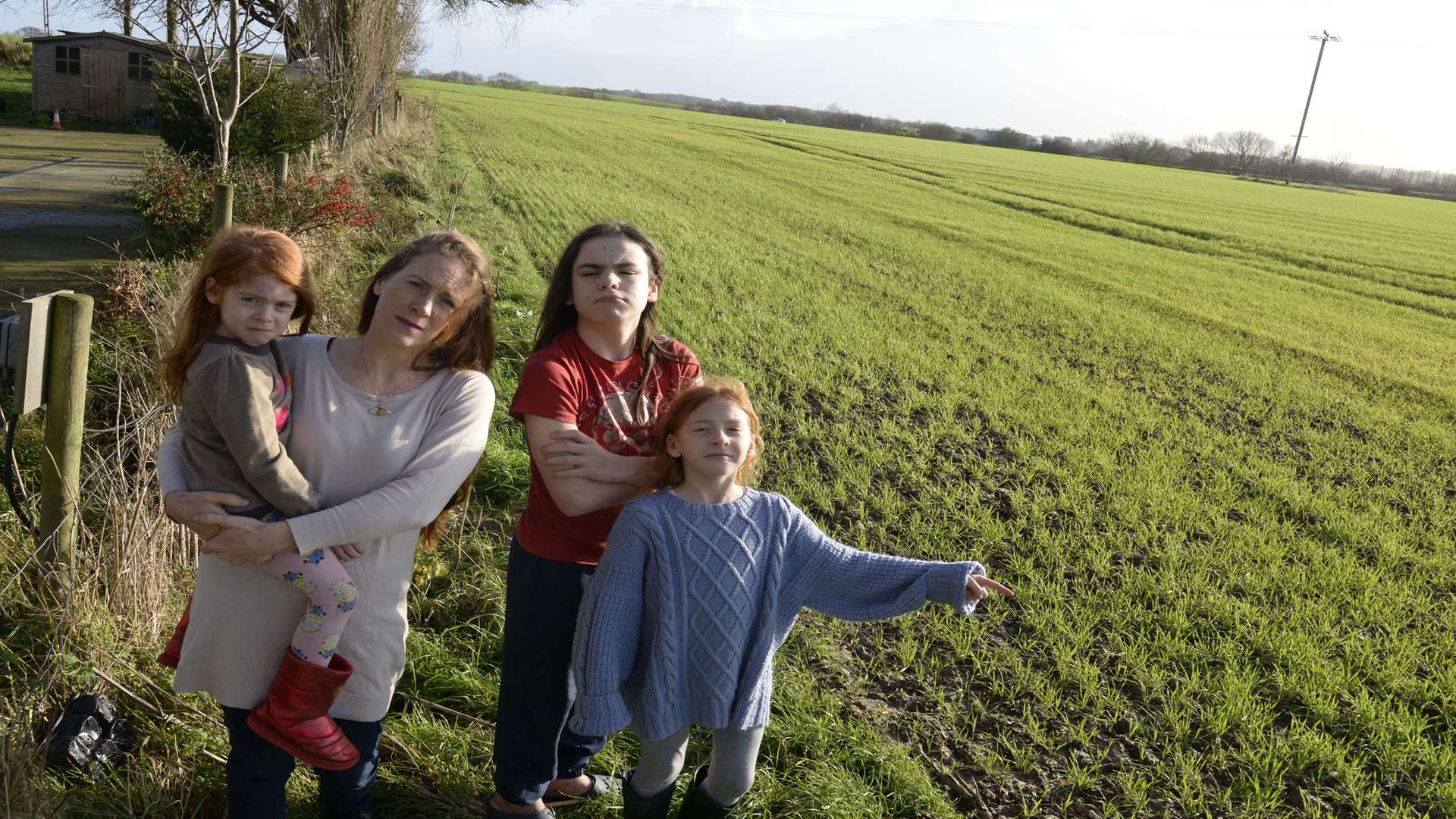 Kelly Isherwood and her children Sid, four, Frederick, 12 and Victar, nine with the land behind their home, the site for the proposed Stanford Est lorry park. Picture: Chris Davey,