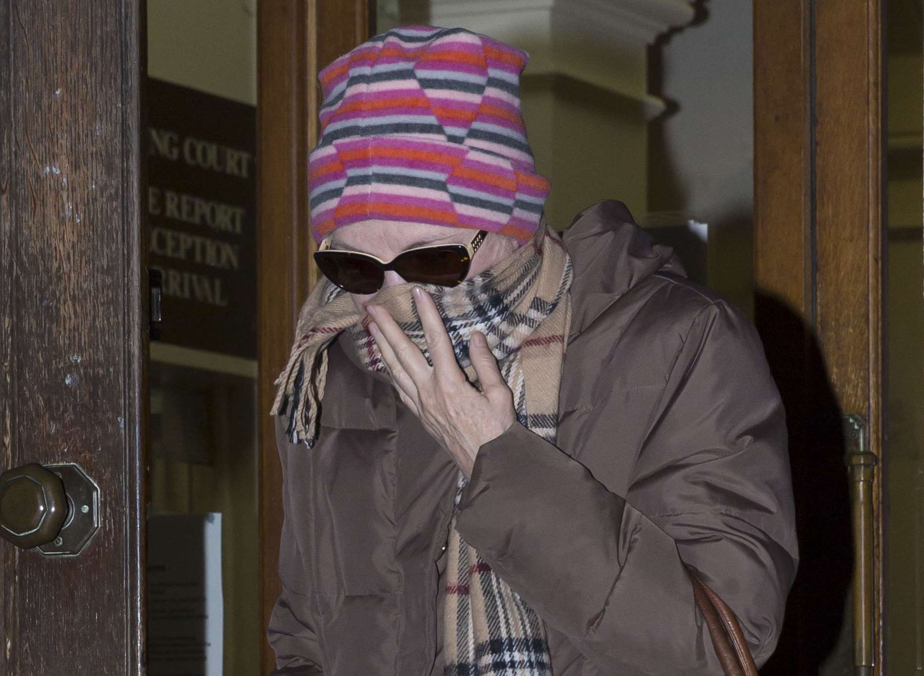 Margaret English shields her face as she leaves court at a previous hearing